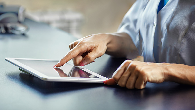 Female mental health clinician using tablet computer in treatment center