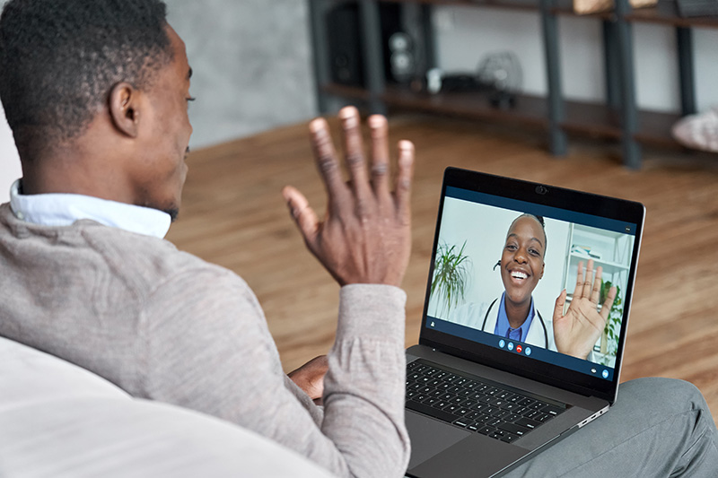 Male African American patient on telehealth conference video call with female online doctor.