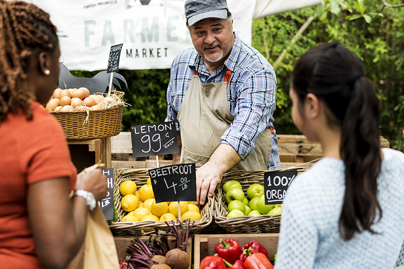 Greengrocer selling organic fresh produce at farmer market