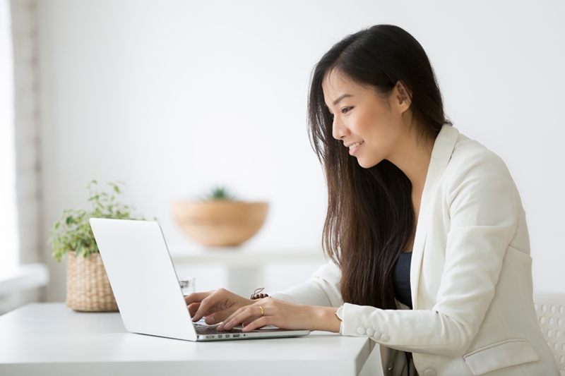 young asian businesswoman using computer at home office workplace doing volunteer work