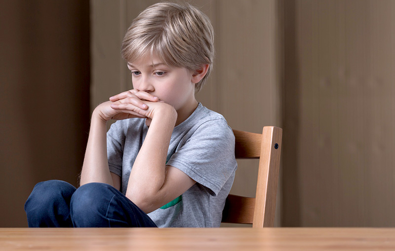 Young boy at school feeling depressed