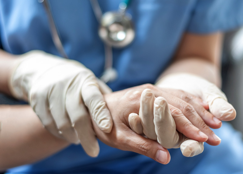 Emergency room doctor holding patient's hand