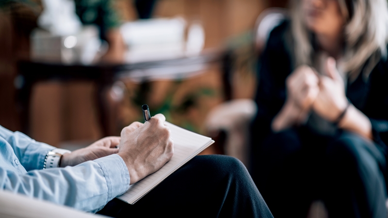 Psychiatrist taking notes during a therapy session