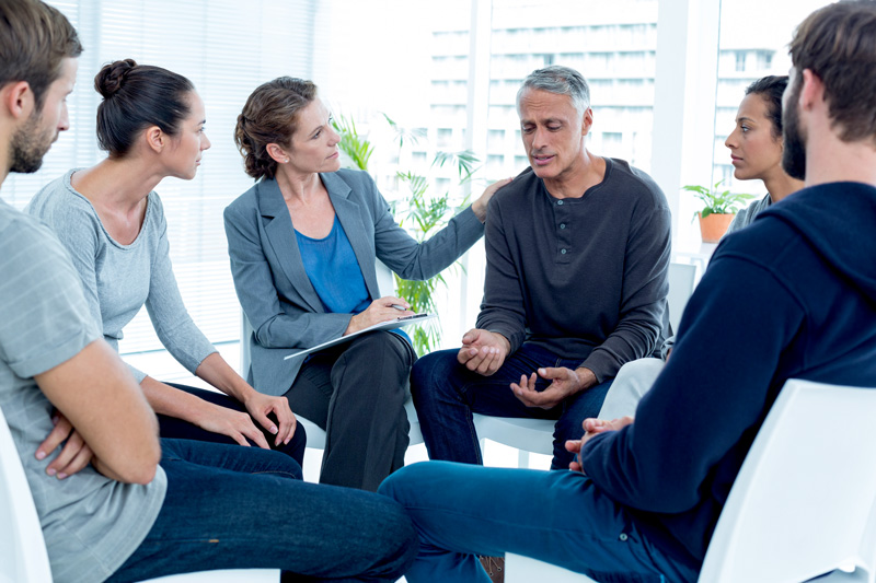 Concerned woman comforting another in rehab group