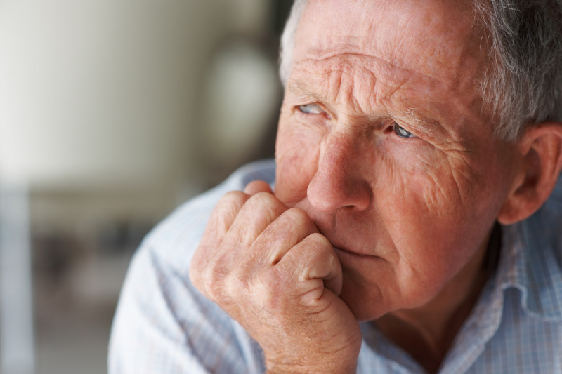 Closeup of a depressed elderly man looking away in deep thought
