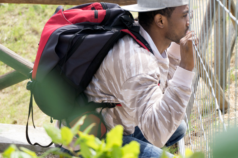 a young immigrant asylum seeker refugee in front of barricade