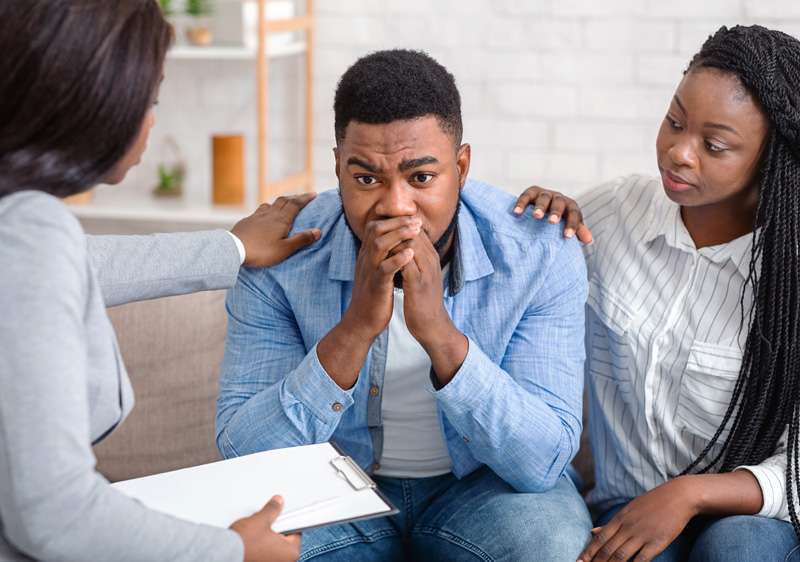 Wife comforting her husband during a family therapy session