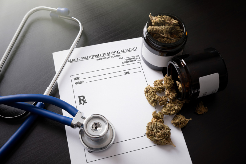 Medical marijuana prescription with dried cannabis buds, prescription bottle, and stethoscope on a table, suggesting the use of cannabis for medical purposes.