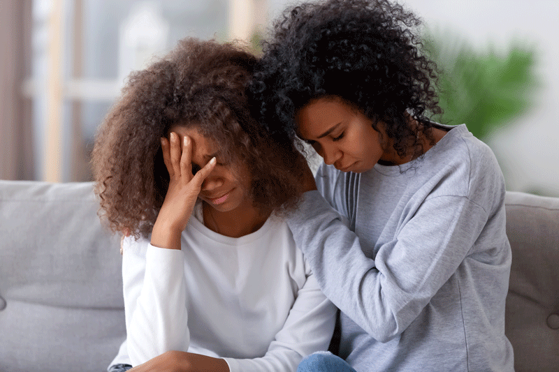 Upset african american mom hugging sad teen girl consoling 