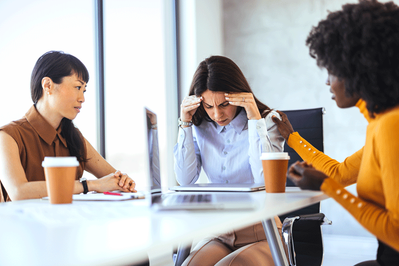 Supportive Colleagues Comforting Stressed Coworker in Office Meeting