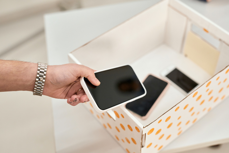 Hand putting phone into box