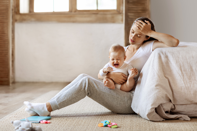 Depressed mom sitting on floor with child on her lap