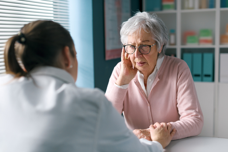 Caring doctor assisting a senior patient
