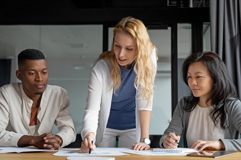Confident businesswoman lead meeting with diverse colleagues in office