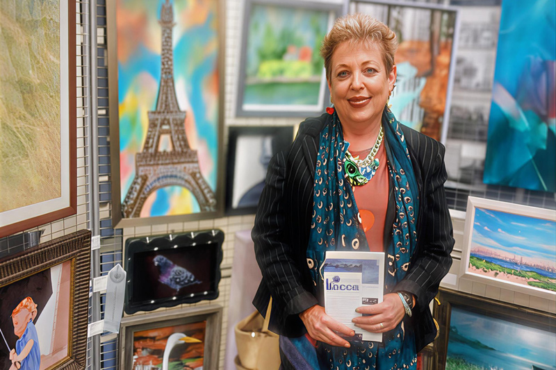 Patricia Masi at an art show in Babylon, NY, with her painting Eiffel Tower, 12" × 18", acrylic on canvas.