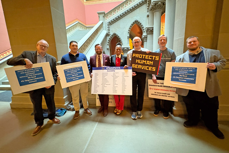 The Mental Health Association in New York State and leading statewide behavioral health and human services organizations have been rallying with legislators at the State Capitol in Albany in support of the final budget for FY 2026-27 including a 4% targeted inflationary increase (formerly known as the cost of living increase). The Photo for 4% Campaign has amassed growing support with over 100 legislators stopping by to take their picture. This investment is critical as these agencies are contending with rising inflationary costs to run these vital programs and recruiting and sustaining their workforce amidst the mental health crisis. Pictured here Assemblymembers Chandler-Waterman and Assemblymember Bronson, Assemblymember Kelles, and Assemblymembers Wright and Romero with the large group of advocates who have shown up day after day. 