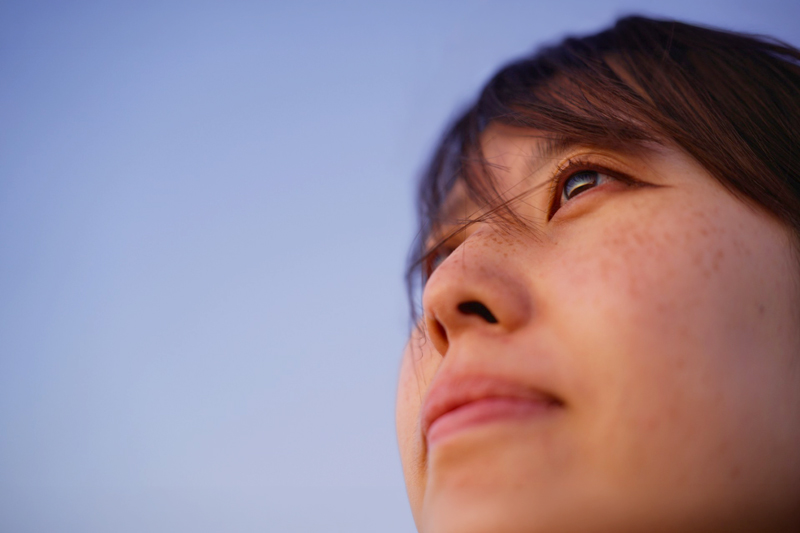A woman's face looking up at the sky